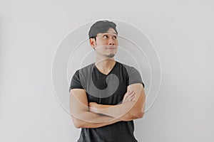 Asian man in black t-shirt crossing his arms isolated on white.