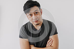 Asian man in black t-shirt crossing his arms isolated on white.