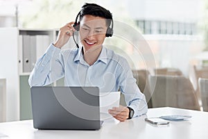 Asian man, call center and laptop with document in customer service, telemarketing or support at office. Happy male
