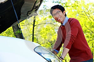 Asian man checking his car engine
