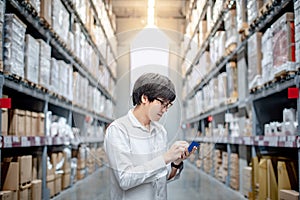 Asian man checking the shopping list in warehouse