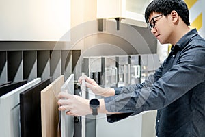 Asian man choosing cabinet or countertop materials