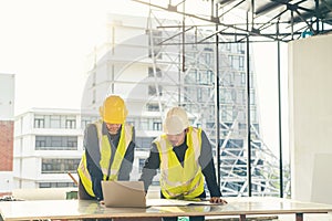 Asian man Civil Engineer and Contractor working with computer laptop on the table in construction site