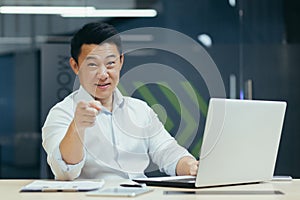 An Asian man conducting online business training. He points at the camera and says, You can do it