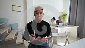 Asian man conducts online job interview making notes