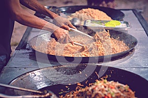 Asian man cooking street food. Unidentified asian people sell food at night market walk street