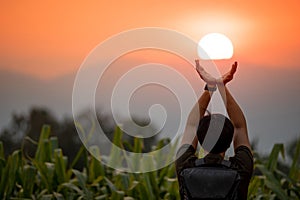 Asian man in corn field holding the sun