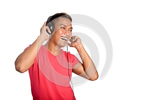 Asian man dances as he listens to his headphones. photo