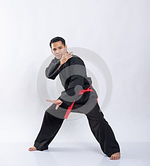 Asian man with a defensive stance while wearing a pencak silat uniform photo
