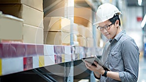 Asian man doing stocktaking by using tablet in warehouse