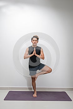 Asian man doing yoga with tree pose. Healthy - Fitness concept