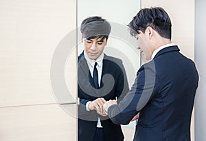 Asian man dressing up for work