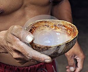 Asian man drinking from coconut shell