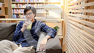 Asian man drinking green tea in bookstore