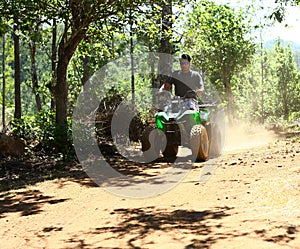 Asian Man Driving All-Terrain Vehicle on Jungle photo