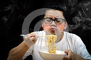 Asian man eating Instant noodles very hot and spicy