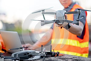 Asian man engineer using drone and laptop for construction site