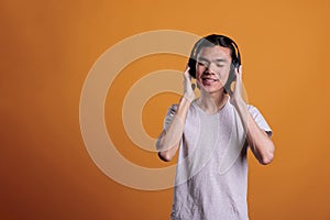 Asian man enjoying music in wireless headphones