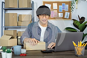 Asian man entrepreneur startup small business entrepreneur SME freelance man working with box to online marketing packaging and