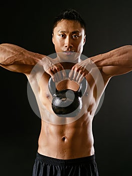 Asian man exercising with kettlebell