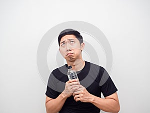 Asian man feeling afraid with water bottle in hand looking up copy space