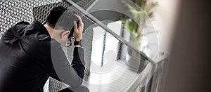 Asian man feeling stressed sitting on stair