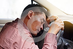 Asian man feels asleep in car, take a nap while driving.