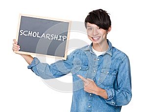 Asian man finger point to chalkboard and showing a word scholars