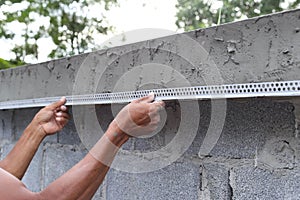 Asian man framing a wet concrete wall