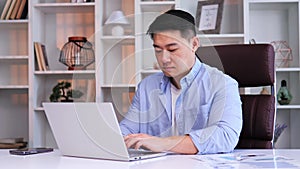 Asian man freelancer coach using laptop studying online working from office.