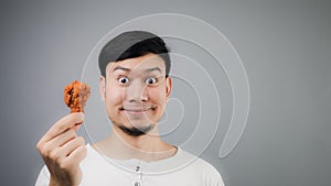 An Asian man with fried chicken.