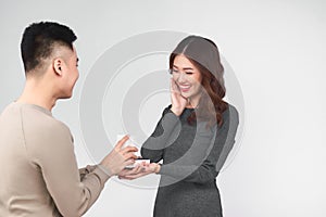 Asian man gives wedding ring and gift box to his woman