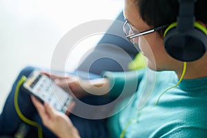 Asian Man With Green Headphones Listens Music Podcast Phone