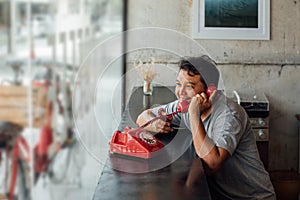 Asian man happy talk phone call in coffee shop