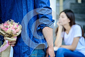 Asian man has preparing and waiting with flower for say sorry an