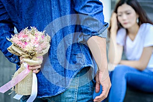 Asian man has preparing and waiting with flower for say sorry an