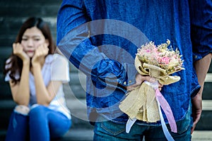 Asian man has preparing and waiting with flower for say sorry an