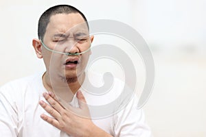 Asian man having asthma and hard to breathing while his hand touching chest. Covid-19 patient in hospital suffer from respiratory photo