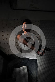 Ázijský muž úkryt v schodisko účtovný pištole 