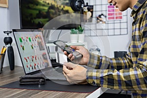 Asian man holding credit card and typing information on internet with laptop at home, online shopping concept