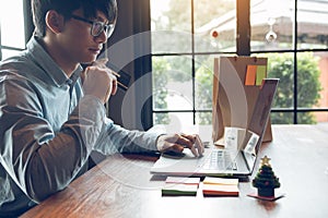 Asian man holding credit card and typing keyboard on laptop with shopping online