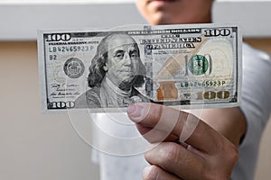 Asian man holding one hundred dollar bill. Wealthy and richness concept