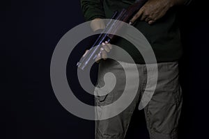 Asian man holds a gun. Gun in his hand isolated on black background