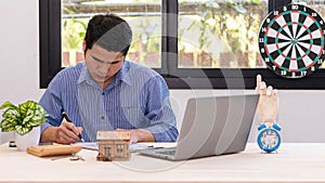 Asian man house sales representative working at desk with contract papers and calculator on desk real estate business ideas for ho