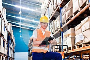 Asian man in industrial warehouse checking list