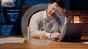 Asian man Korean sick ill businessman office worker overworked at night evening with laptop business project suffer