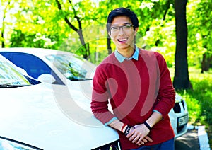 Asian man leaning on the car