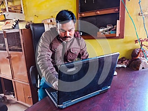 asian man learning about laptop computer system at shop counter in india January 2020