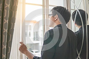 Asian man looking out of the window