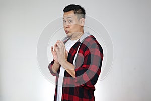 Asian man looking to camera with embarrased worried hoping something gesture, shocked expression